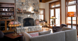 a well-decorated living room with a fireplace and sunshine streaming in
